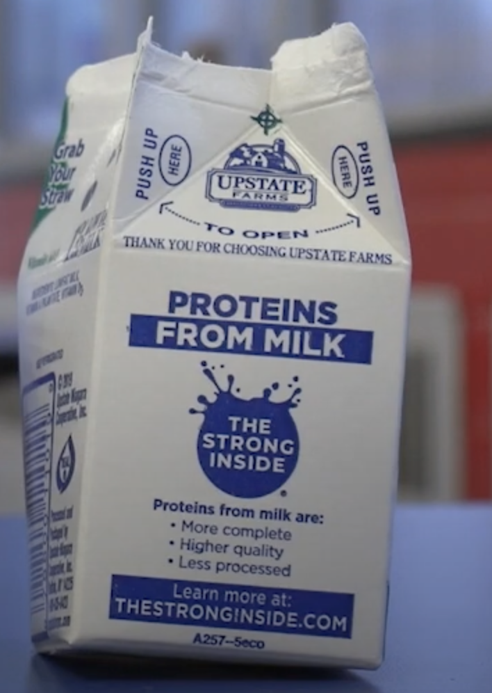 A Milk Carton from Upstate Farms. It is white with blue text.